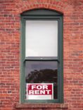 Apartment window with For Rent sign in it.