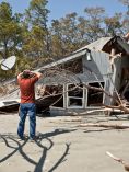 Man Assessing Storm Damage to Home
