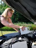 Woman adding oil to engine