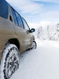 Gold SUV driving in snow.