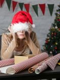 Woman wearing Santa hat stressed out about Christmas