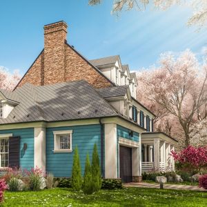 A blue house with cherry blossom trees in the yard